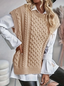 Women's cream cable knit vest with round neck and side slits over white shirt
