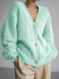 Detailed texture of mint green longhair mohair cardigan with yellow buttons and V-neckline