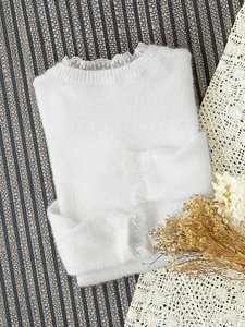 Vue détaillée d'un pull en maille blanc avec poignets en dentelle et col en dentelle fine