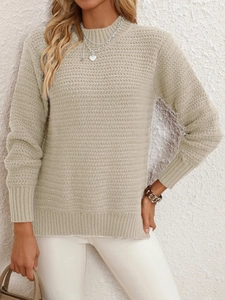 Detail shot of beige knit sweater showing elegant wavy texture and ribbed cuffs