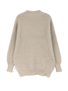 Close-up of oatmeal knit sweater showing intricate wave texture and ribbed cuffs