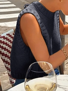 Detail of dark grey knit sleeveless vest with ribbed crewneck and thick texture