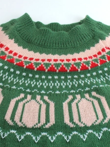 Dark green knitted sweater with festive red and white patterns for Halloween and autumn