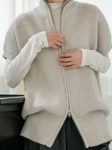 Dettaglio del gilet in maglia a coste beige con collo alto e cerniera metallica resistente