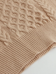 Detail of premium cable knit texture and ribbed hem on a beige sleeveless knit vest