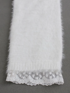 Jambières blanches en tricot duveteux avec bordure en dentelle sur fond gris