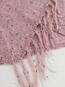 Dettaglio ravvicinato del maglione in maglia rosa con fibre miste e lunghe frange