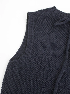 Detailed close-up of dark blue knit vest showing premium textured fabric and neckline finish