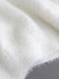 Close-up of soft white fuzzy knit sweater texture with high-quality plush fabric detail