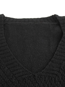 Close-up of classic black V-neck knitted vest showing fine texture and knit detail