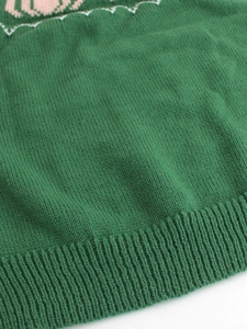 Green knit sweater with contrast pink pattern and ribbed hem detailing