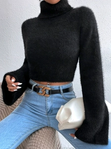 Detail of black cropped turtleneck sweater featuring soft mohair texture and flared sleeves