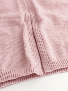 Pink knit cardigan featuring soft wool texture, ribbed hem and fine knit details