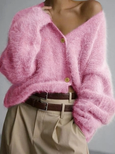 Detail of soft pink fuzzy knit cardigan featuring V-neckline and round buttons texture