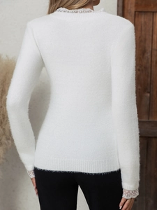 Vue détaillée du dos d'un pull blanc avec dentelle délicate au col et aux poignets
