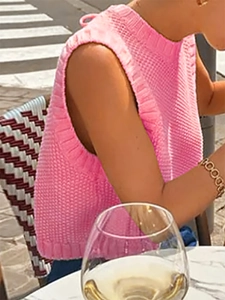 Detailed macro of bright pink sleeveless knit vest with hollow textured honeycomb weave