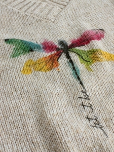Women's V-neck beige knit sweater featuring a colorful dragonfly print and let it be text