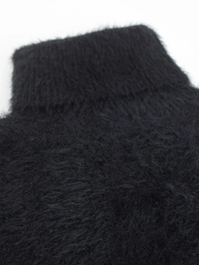 Close-up of black fuzzy knit turtleneck sweater showing soft plush texture and collar