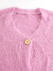 Detailed view of pink fuzzy knit cardigan showing soft mohair texture and button detail