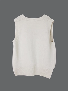 Close-up of the back view of this cream knitted vest featuring ribbed edges and soft texture