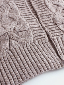 Beige cable knit cardigan with vintage textured patterns and ribbed hem detail