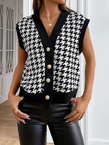 Dettaglio del gilet in maglia pied de poule con scollo a V e bottoni dorati a rilievo