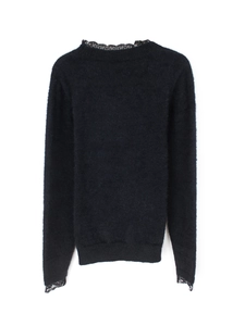 Gros plan sur un pull noir en maille avec des détails raffinés en dentelle aux poignets