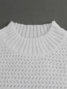 Detailed view of white knit sweater featuring delicate hollow wavy patterns and ribbed collar