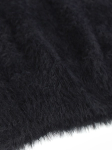 Close-up of soft black plush knit fabric texture with fuzzy mohair-like sweater fibers