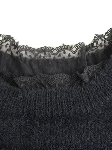 Gros plan d'un pull en maille pelucheuse noire avec col en dentelle et détails en résille