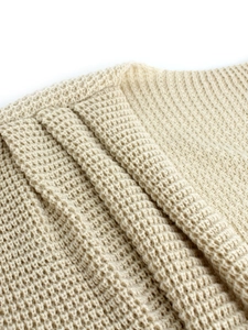 Women's long-sleeve beige knit sweater with a chunky waffle texture and relaxed fit