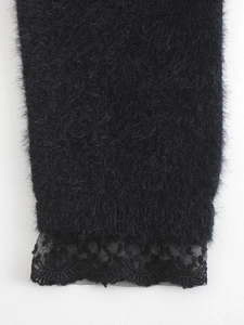 Détail de la manche en maille noire duveteuse avec bordure en dentelle délicate