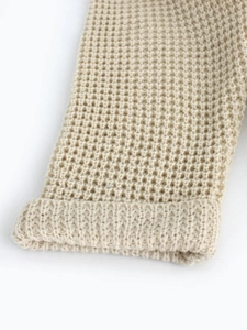 Women's mid-length waffle knit cardigan in beige, close-up of soft textured fabric