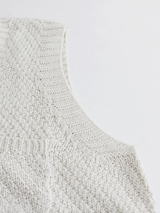 Detailed macro view showing the textured knit pattern of this cream white V-neck vest