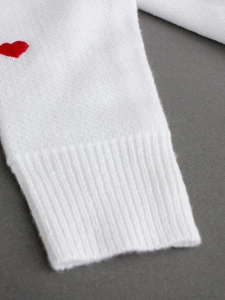 Maglione in maglia bianca con scollo a V, ricamo a cuore rosso e polsini a costine