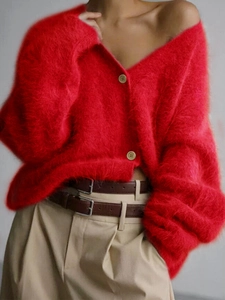 Detail of red knitted cardigan showing soft fuzzy texture and round button fasteners