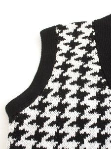 Dettaglio macro del tessuto in maglia pied de poule con bordo nero a coste sul gilet