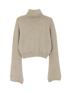 Detailed view of women's turtleneck knit sweater with soft fluffy texture and ribbed cuffs