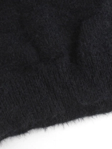 Gros plan sur le tricot noir à longs poils avec détails côtelés et texture douce