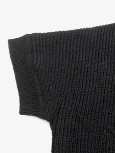 Dettaglio della trama in maglia a coste nera di alta qualità sulla manica del cardigan