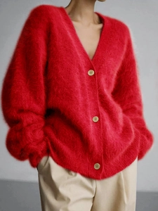 Close-up of fluffy red V-neck knit cardigan with textured faux rabbit fur and beige buttons