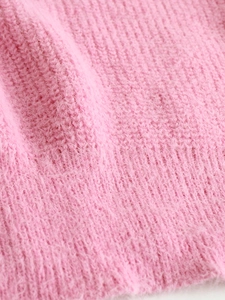 Detailed macro view of pink ribbed knit sweater fabric with soft fuzzy texture