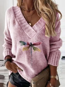 Detail of V-neck pink knit sweater featuring artistic dragonfly print and let it be text