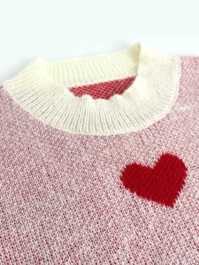 Pink and white knit pullover sweater with round neck and red heart jacquard pattern