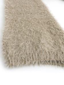 Close-up of soft beige plush knit fabric texture with high-quality fuzzy long fibers