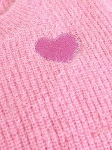 Pink crewneck knit sweater with fuzzy texture and a dark pink heart patch on the chest