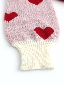 Knit sweater sleeve detail with red heart pattern and ribbed cuff in pink white mix