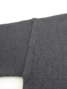 Detailed close-up showing the high-quality stitching and rib-knit texture of the grey sweater