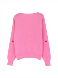 Dettaglio maglione rosa in maglia con ricamo a cuore rosso sulle maniche e polsini a coste
