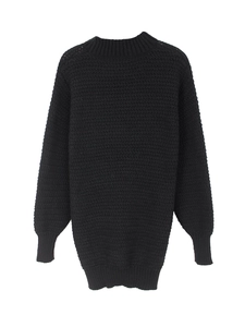 Close-up of black knitted sweater showing textured wavy pattern and ribbed crew neck details